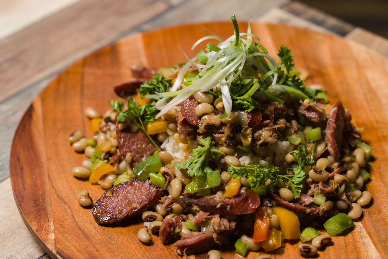A plated catering dish of hoppin' john with smoked sausage and fresh herbs